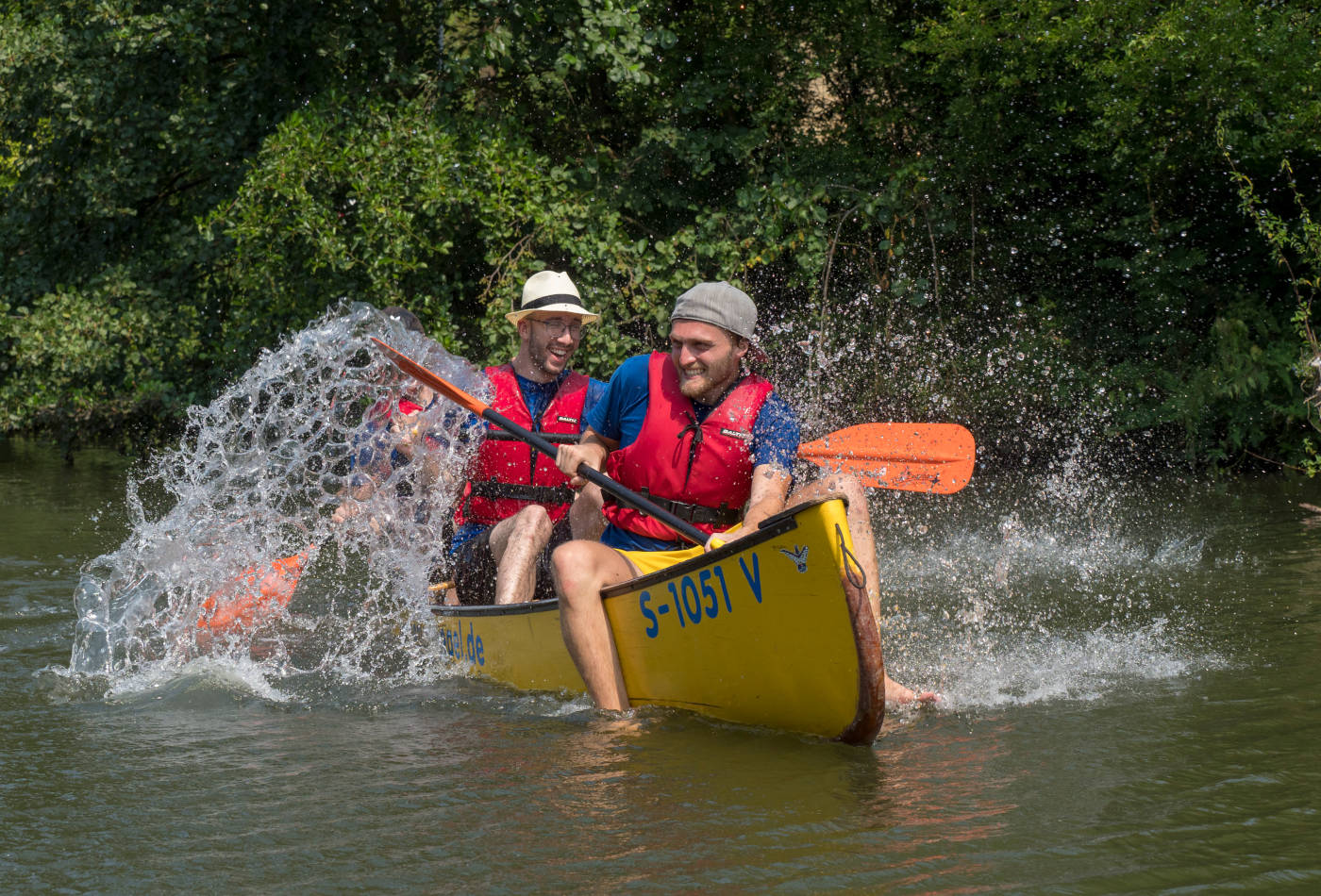 Eine Gruppe Menschen in den Weinbergen, im Hintergrund der Neckar.