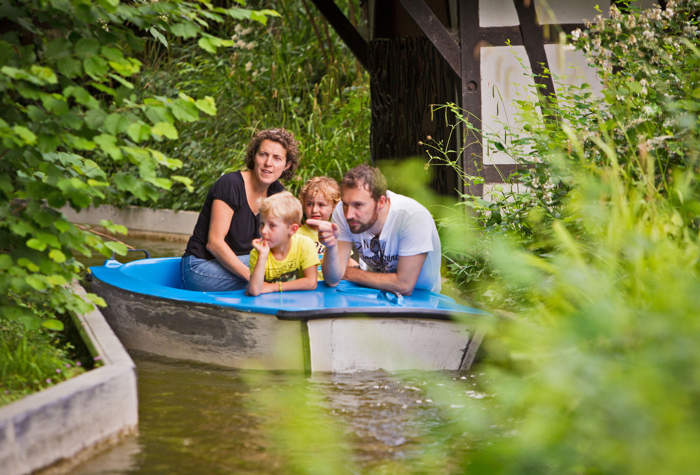 Familie in einem Boot auf einem Bach im Märchengarten